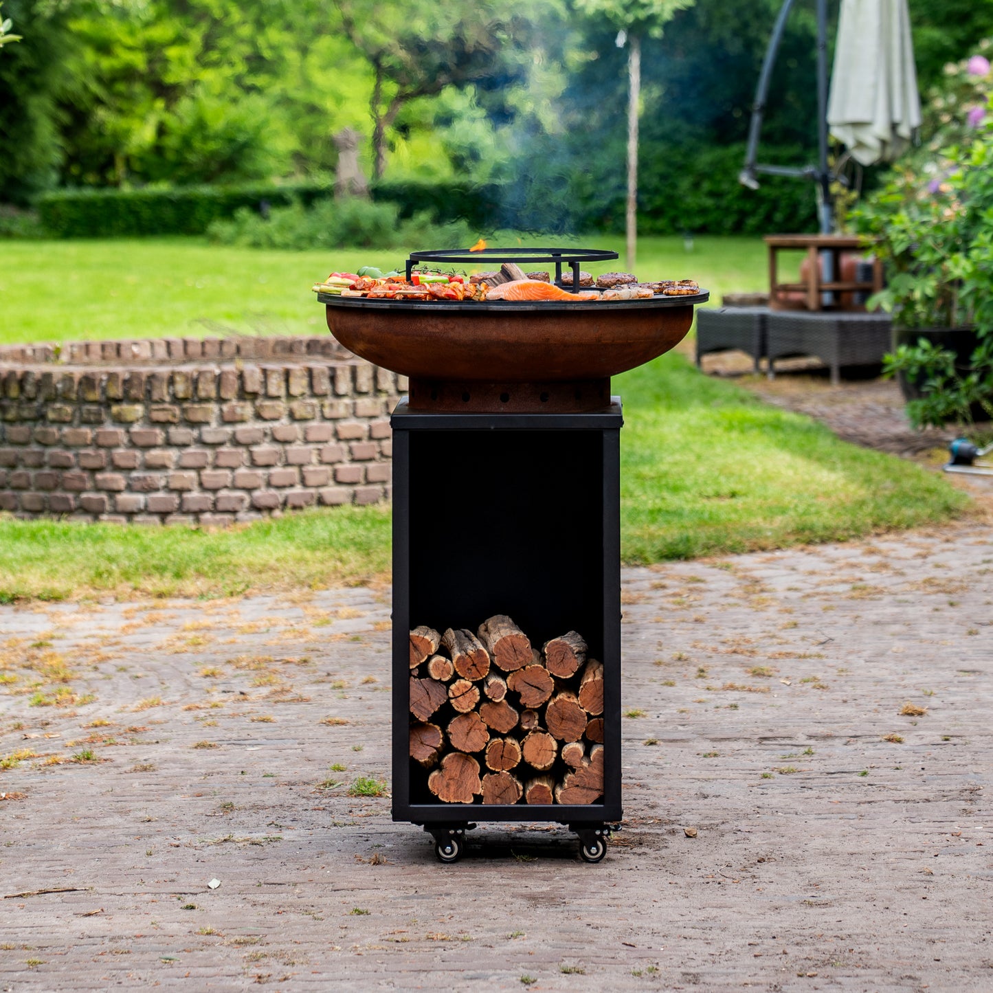 BBQ Plancha Grill Cortenstaal Blackline 8mm Camarada 2.0 - Met pook en houtopslag Ø70cm